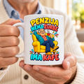 Bela šolja sa natpisom Penzija, nema žurbe, ima kafe i nasmejanim penzionerom u žutoj fotelji, u rukama starijeg muškarca
