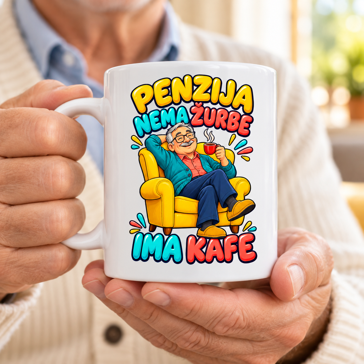 Bela šolja sa natpisom Penzija, nema žurbe, ima kafe i nasmejanim penzionerom u žutoj fotelji, u rukama starijeg muškarca