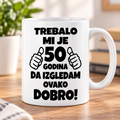 Bela šolja sa natpisom Trebalo mi je 50 godina da izgledam ovako dobro – poklon za 50. rođendan